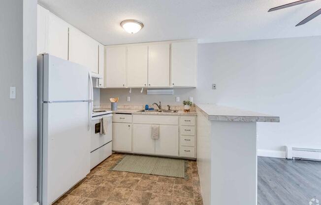 a kitchen with white cabinets and a refrigerator