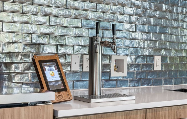 a kitchen sink with a tablet on the counter