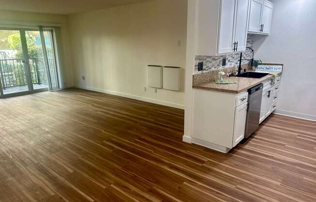 A kitchen with white cabinets and a wooden floor. at Willow Tree Apartments, California, 90505