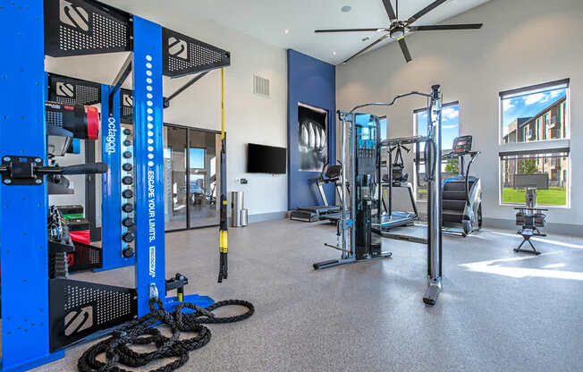 A gym with a variety of equipment including a weight rack, treadmill, and exercise bike.