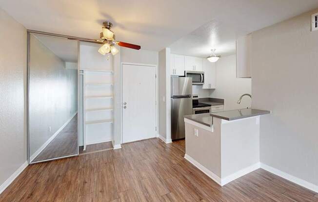 A kitchen area with a refrigerator, microwave, and stove top oven.