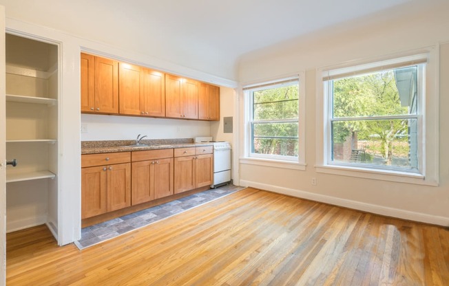 an empty kitchen with wood floors and wooden cabinets