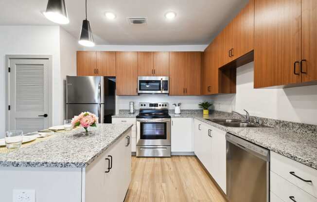 a modern kitchen with granite counter tops and stainless steel appliances at Gibson Oaks, Lakeland, 33809