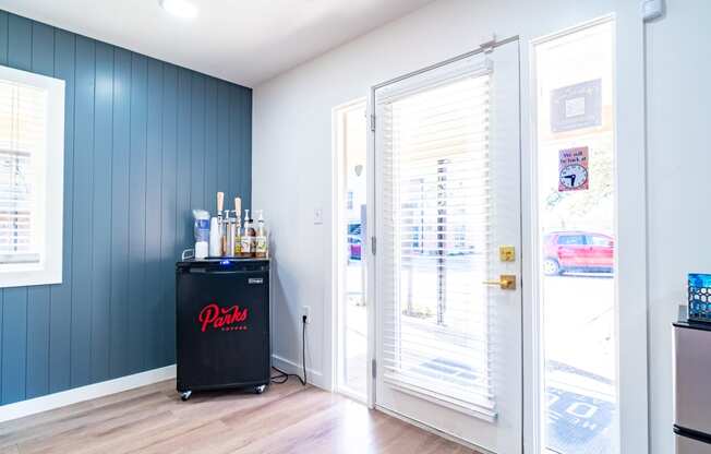 a bar in the corner of a room with blue walls and a glass door