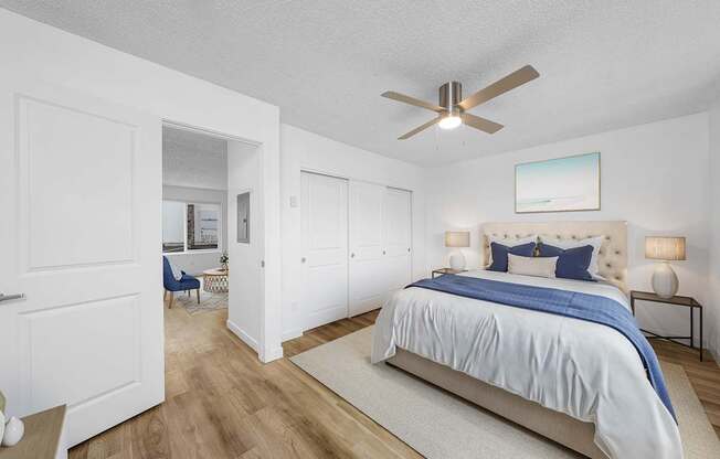 A bedroom with a large bed and a ceiling fan.