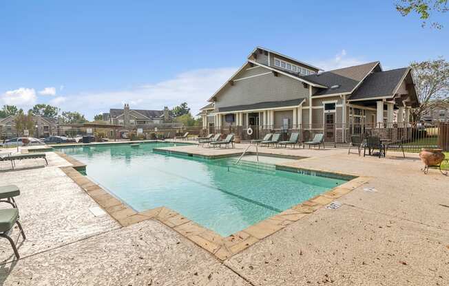 A large swimming pool in front of a house.