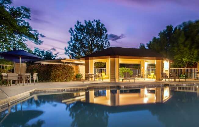 the pool and pavilion of a resort at night