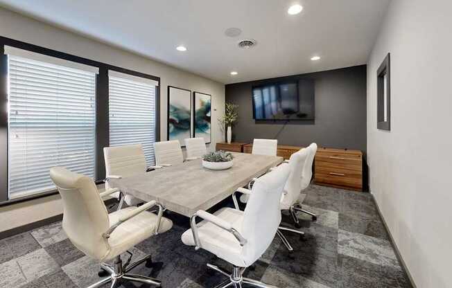 A conference room with a long table and chairs.