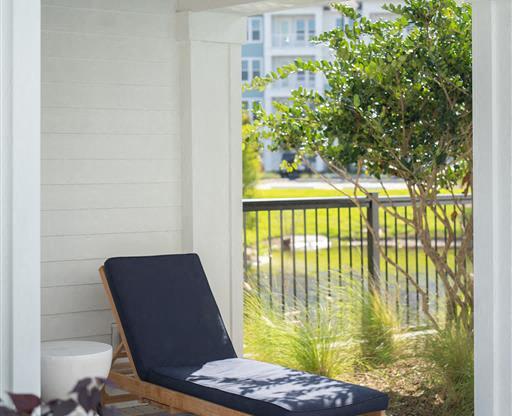 a porch with a chair and a ceiling fan