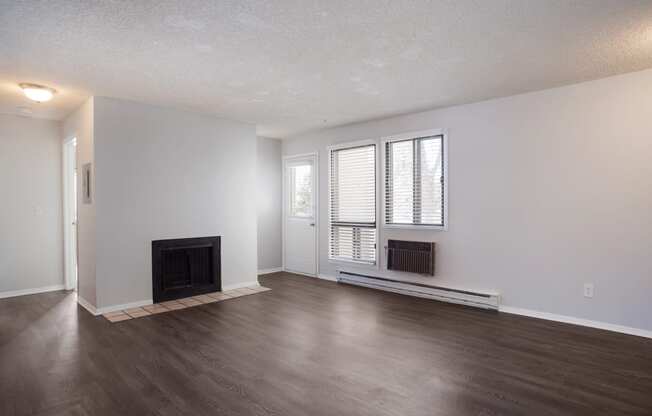 Empty living room with a fireplace and wooden floors  at Governor's Park, Fort Collins, 80525