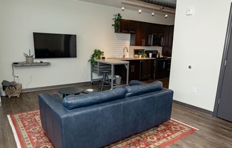 a living room with a couch and a kitchen in the background