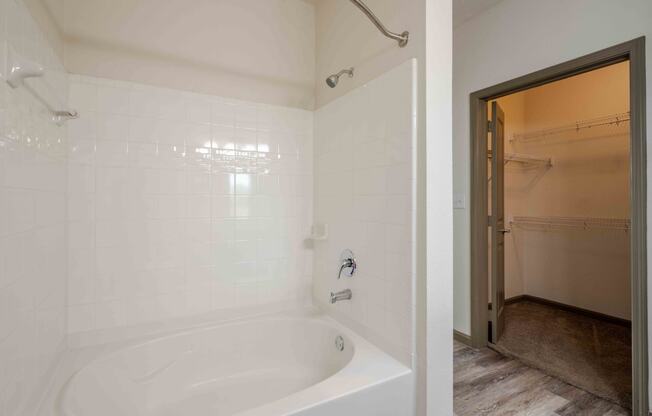 a bathroom with a bathtub and shower at Parc at Bentonville Apartments in Bentonville, AR