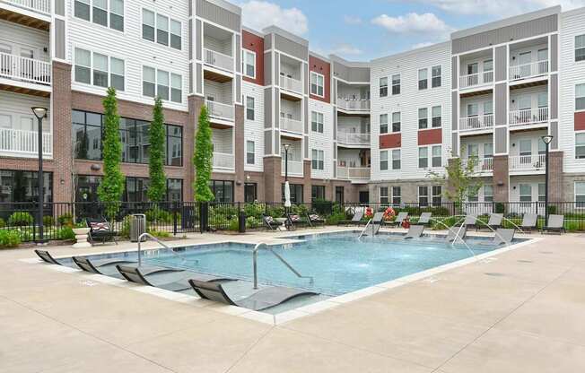 A swimming pool in front of apartment buildings.