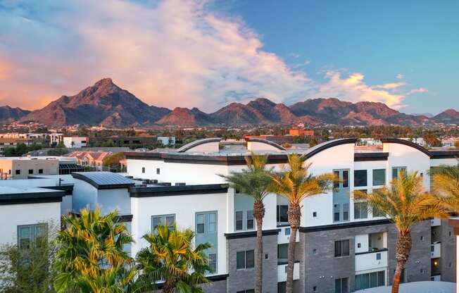 an aerial view of apartments with palm trees and mountains in the background