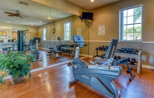 a workout room with weights and a reformer in a home gym