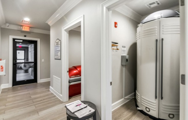 a room with two refrigerators and a door to a bedroom at Crossgates Apartment Homes, Starkville, 39759