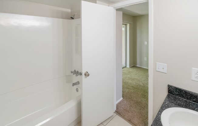 a white bathroom with a sink and a shower