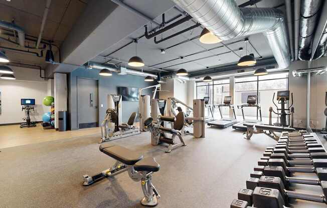 A gym with a variety of equipment including weights and exercise machines.