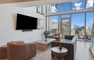 living room with leather furniture and a large window with a view of the city