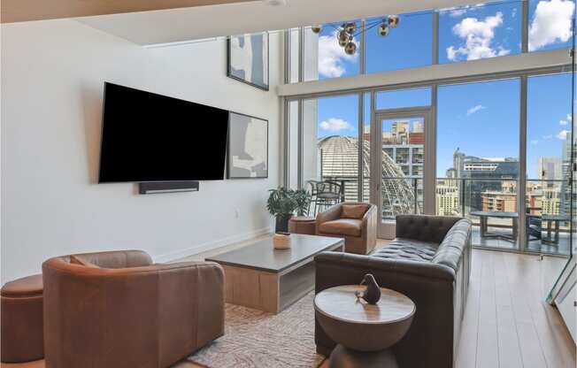 living room with leather furniture and a large window with a view of the city