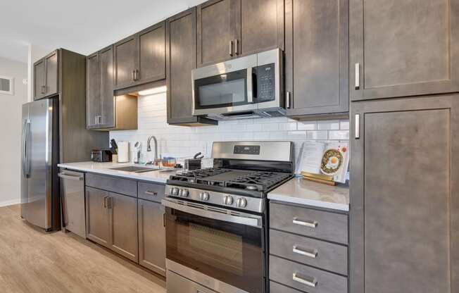 a kitchen with dark wood cabinets and stainless steel appliances