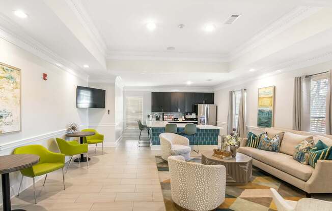 a living room with a couch and chairs and a kitchen at Avalon Apartment Homes in Starkville, Mississippi
