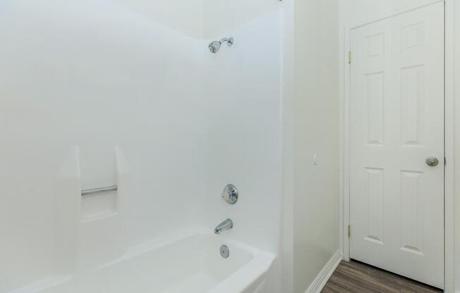 a white tub sitting next to a shower