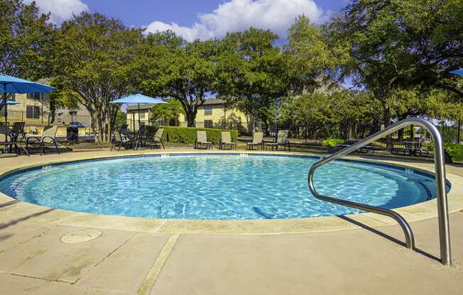 a resort style pool with a slide and chairs and umbrellas