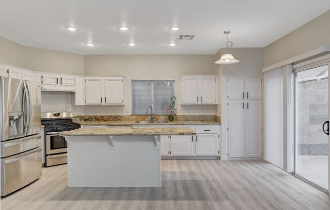Elegant kitchen open to family room with fireplace.