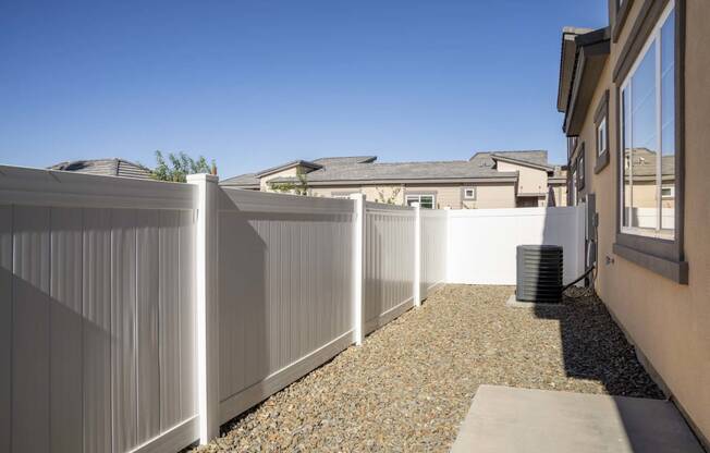 a white fence in a backyard next to a house at Grandstone at Sunrise, Peoria, AZ