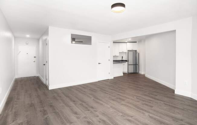 a bedroom with a medium hardwood floor and white walls