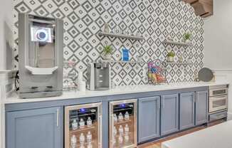 a bar with blue cabinets and a coffee machine