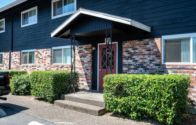 A blue apartment building with a red door