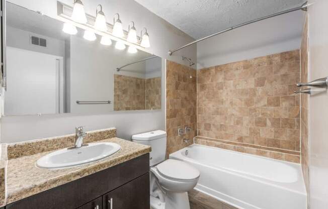 A bathroom with a sink, toilet, and bathtub.