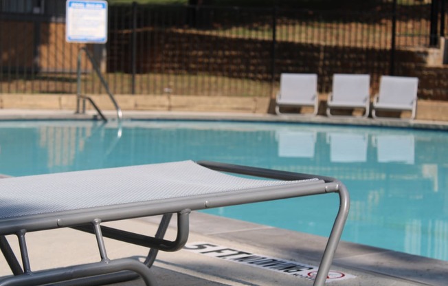 a swimming pool with a pool chair next to it