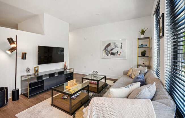 a living room with a couch and a television at Link Apartments® 4th Street, Winston-Salem, NC