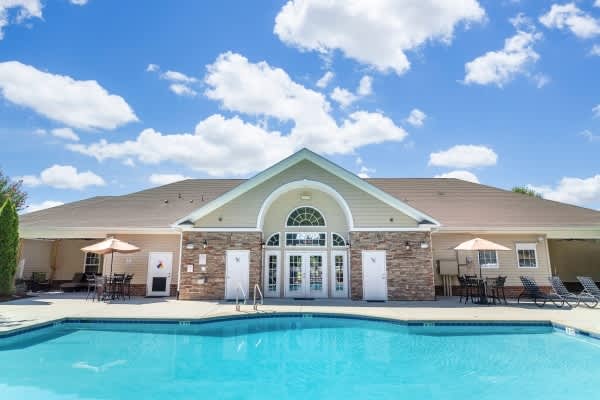 A house with a pool in front of it.