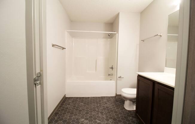 a bathroom with a white toilet next to a white bathtub