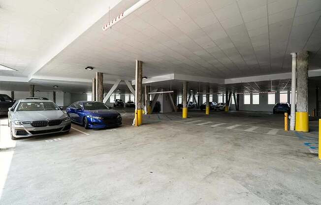 A parking garage with two cars parked.