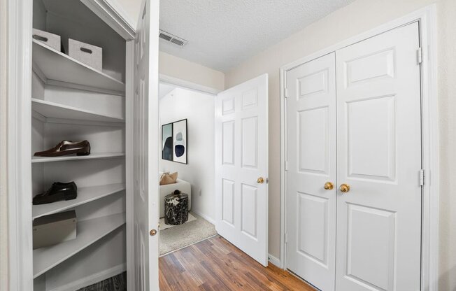 A hallway with white doors and a shoe rack.