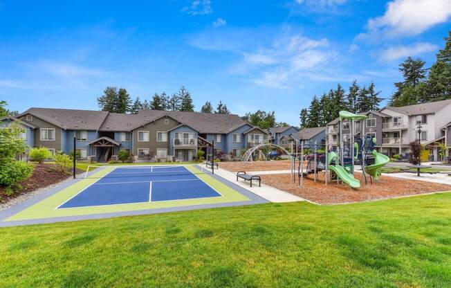 Tennis Courts and Playground, Wood Chip Floor, Grass, and Apartment Exteriors