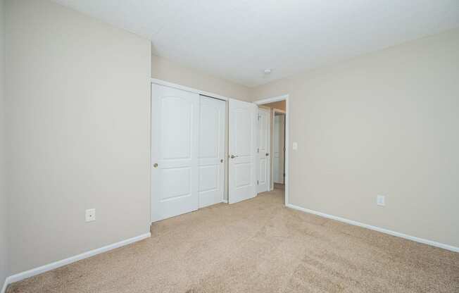 a bedroom with two closets and a door to a hallway