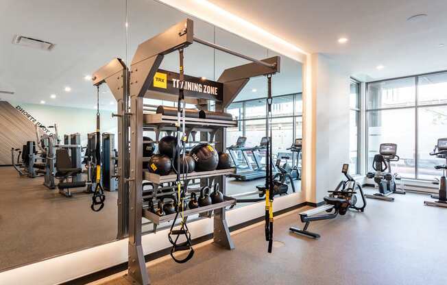 A gym with a variety of equipment including a TRX suspension trainer.