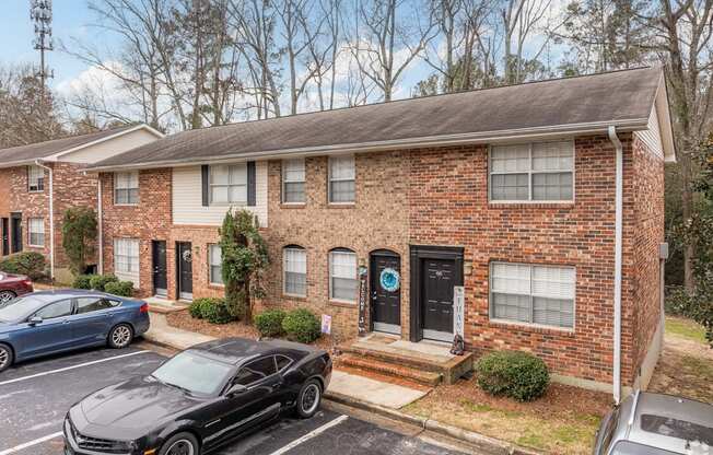 a brick house with cars parked in front of it