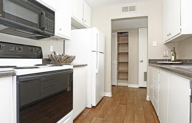 Kitchen with stove, microwave, refrigerator, and lots of cabinets.