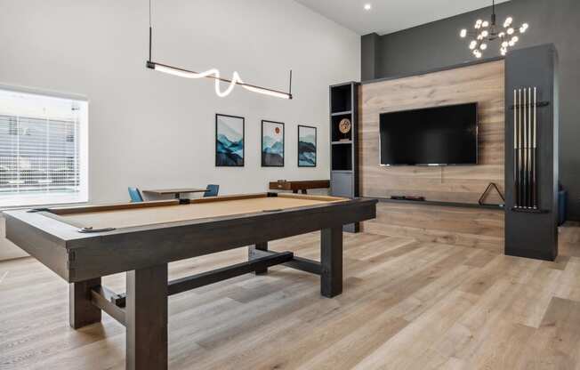 a games room with a pool table and a tv
