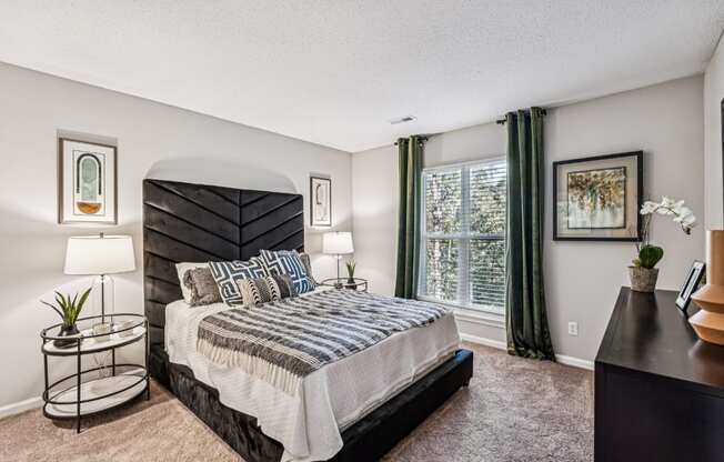 A bedroom with a large bed and a nightstand.