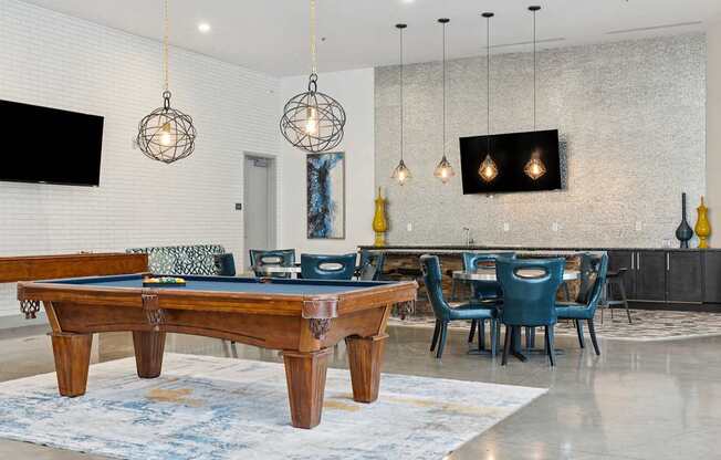 A room with a pool table and a television mounted on the wall.