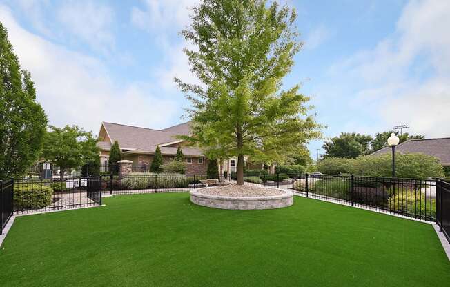 a yard with a tree and a house in the background at Sovereign at Overland Park, Overland Park, KS 66213  