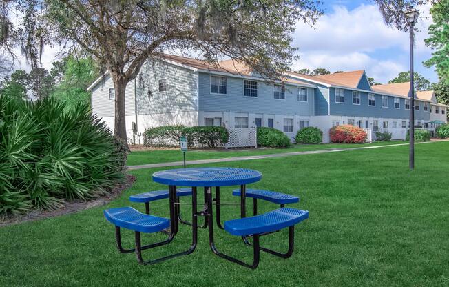 a couple of lawn chairs sitting on top of a grass covered field